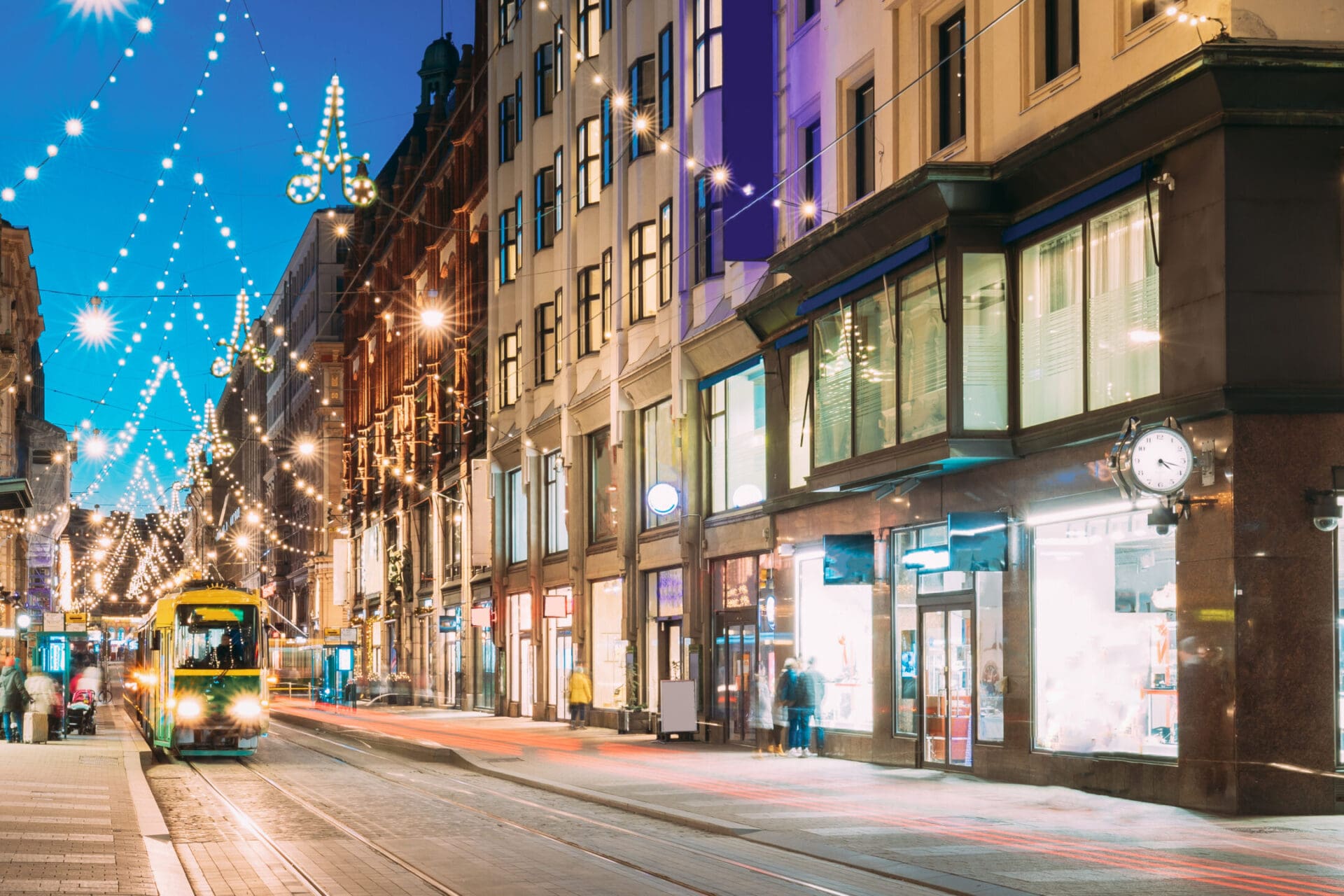 Helsinki, Finland. Tram Departs From Stop On Aleksanterinkatu Street. Street With Railroad In Kluuvi District In Evening Or Night Christmas Xmas New Year Festive Illumination